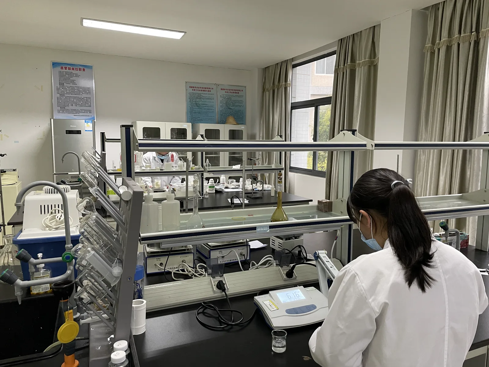 Formulation technician reviewing mouthwash samples and pH in the laboratory