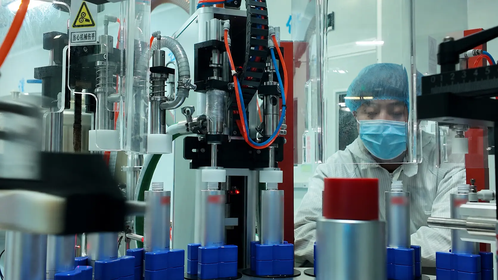 Operator working beside an anonymized bottled mouthwash production line